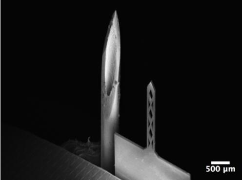 开孔钛基微针（200um宽，50um厚，1500um长）和26G皮下注射针（外径464um）对比的扫描电子显微镜照片